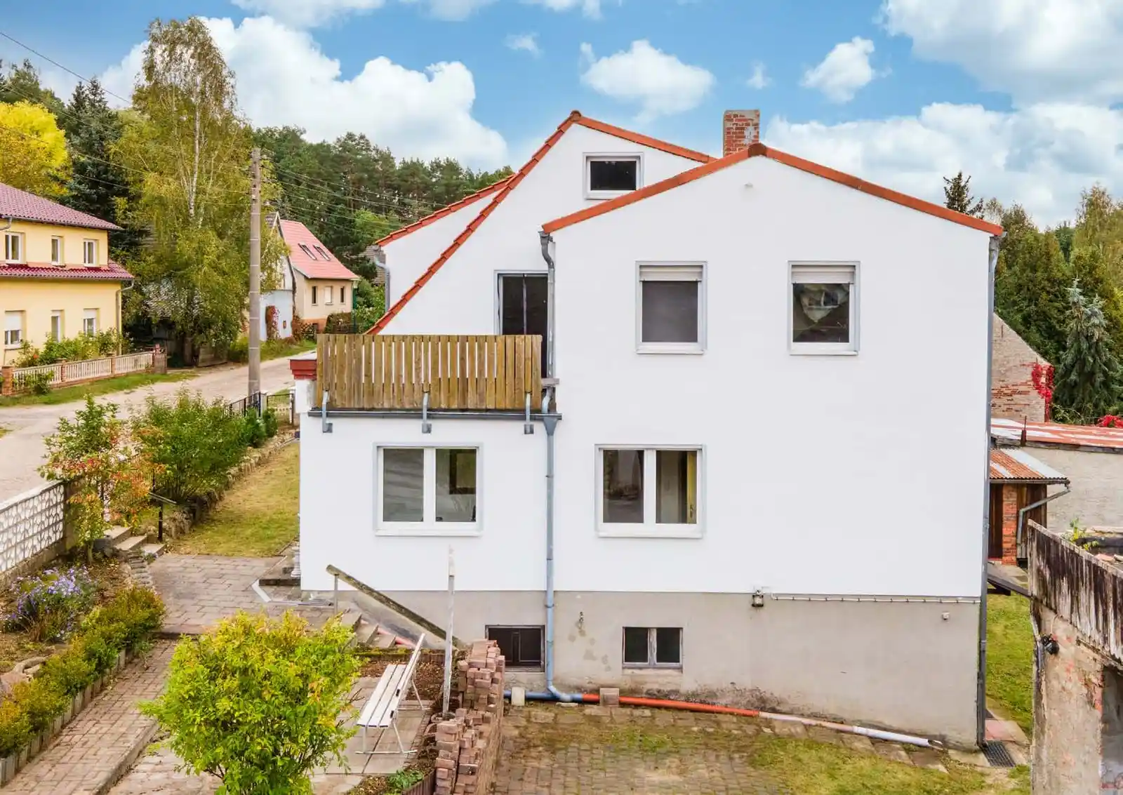 Weißes Ein- oder Mehrfamilienhaus mit Anbau und Garten in Neuzelle