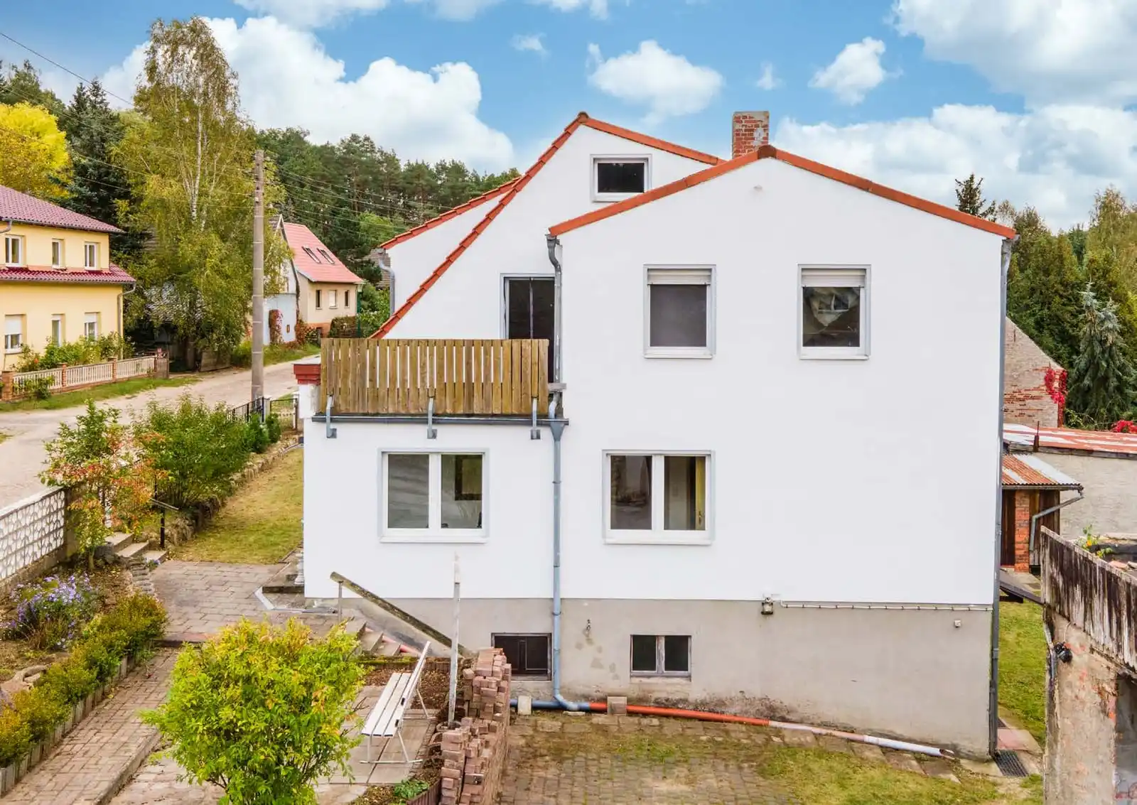 Weißes Ein- oder Mehrfamilienhaus mit Anbau und Garten in Neuzelle