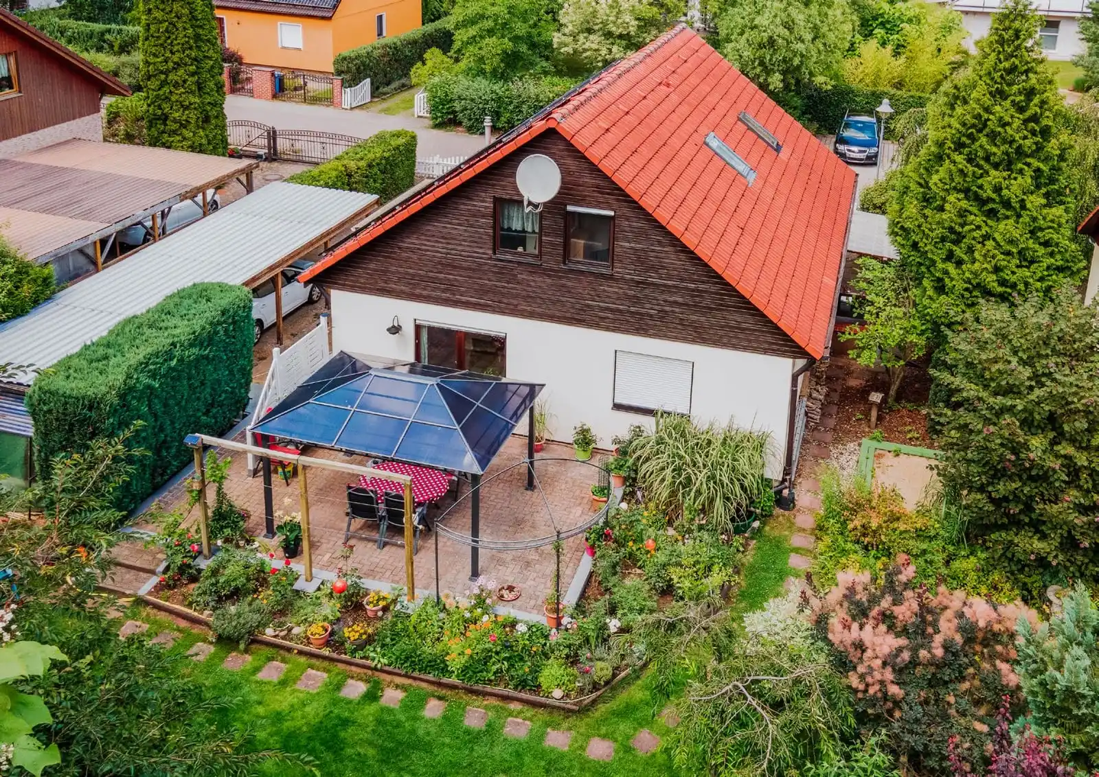 Drohnenaufnahme des Einfamilienhauses mit rotem Dach, Pavillon und Garten in Borkheide