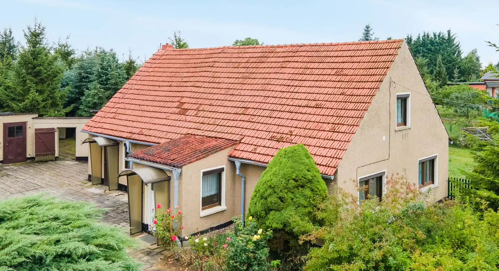 Einfamilienhaus mit rotem Ziegeldach, Anbau und Garagen in Neuhof bei Angermünde
