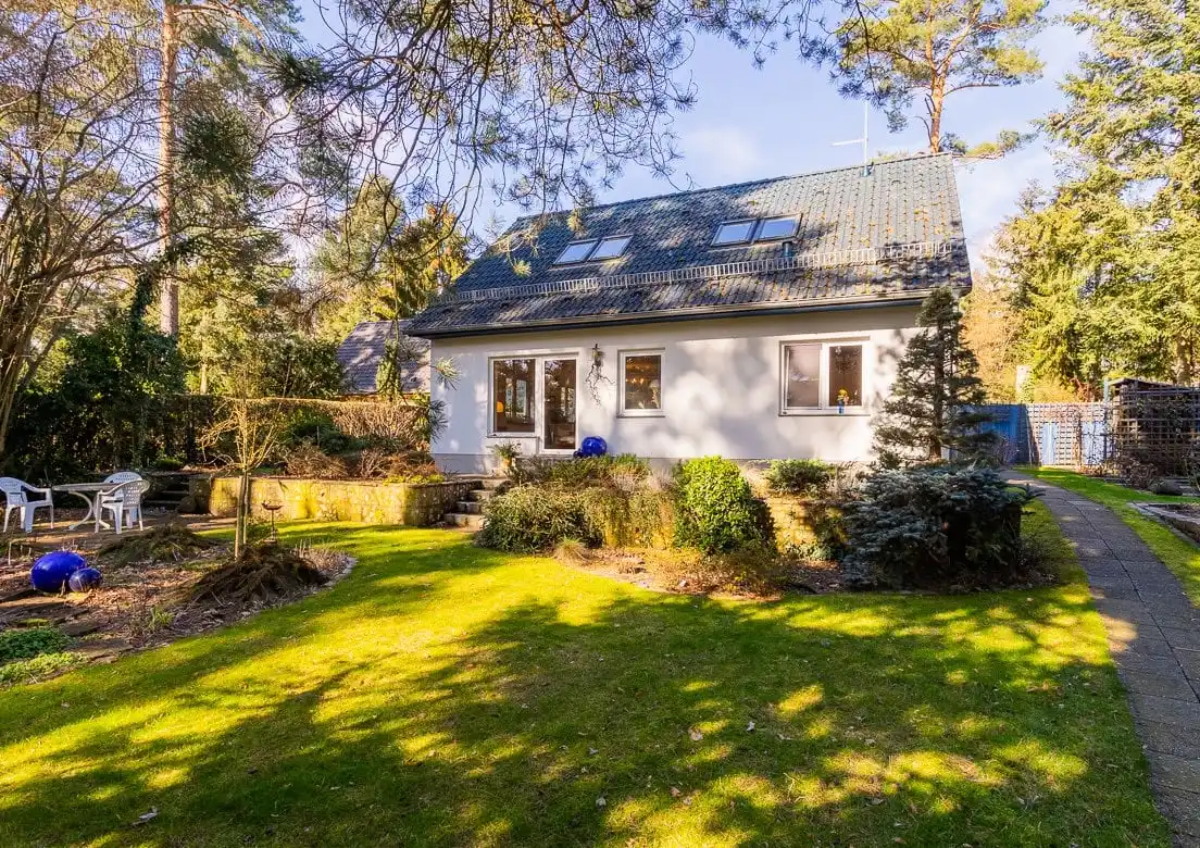 Helles Einfamilienhaus mit Dachfenstern, Garten und Kiefern in Wandlitz im Winterlicht