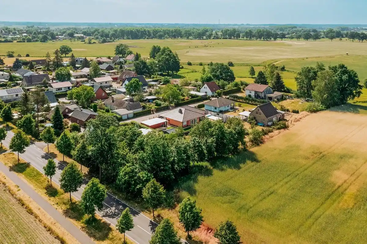Drohnenaufnahme über Schwante bei Oberkrämer im Landkreis Oberhavel, Einfamilienhäuser am Ortsrand, Baumreihe an der Landstraße, dahinter Felder