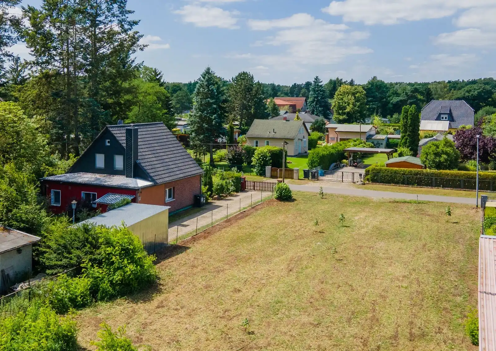 Beräumtes Baugrundstück mit Rasen zwischen Einfamilienhäusern in Spreewerder bei Grünheide