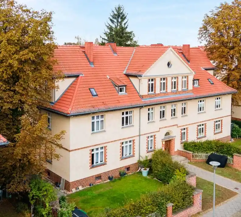 Mehrfamilienhaus mit roten Ziegeldächern und Vorgarten im Herbst in Hennigsdorf, Lage der Eigentumswohnung