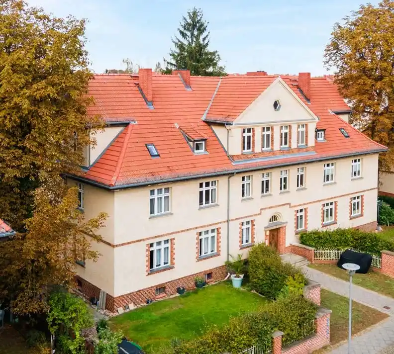 Mehrfamilienhaus mit roten Ziegeldächern und Vorgarten im Herbst in Hennigsdorf, Lage der Eigentumswohnung
