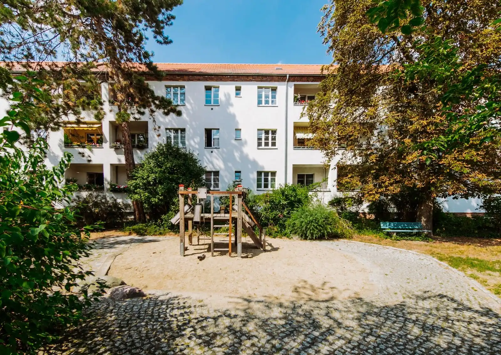 Innenhof mit Spielplatz und Bäumen vor dem Wohnhaus der Eigentumswohnung in Berlin-Adlershof