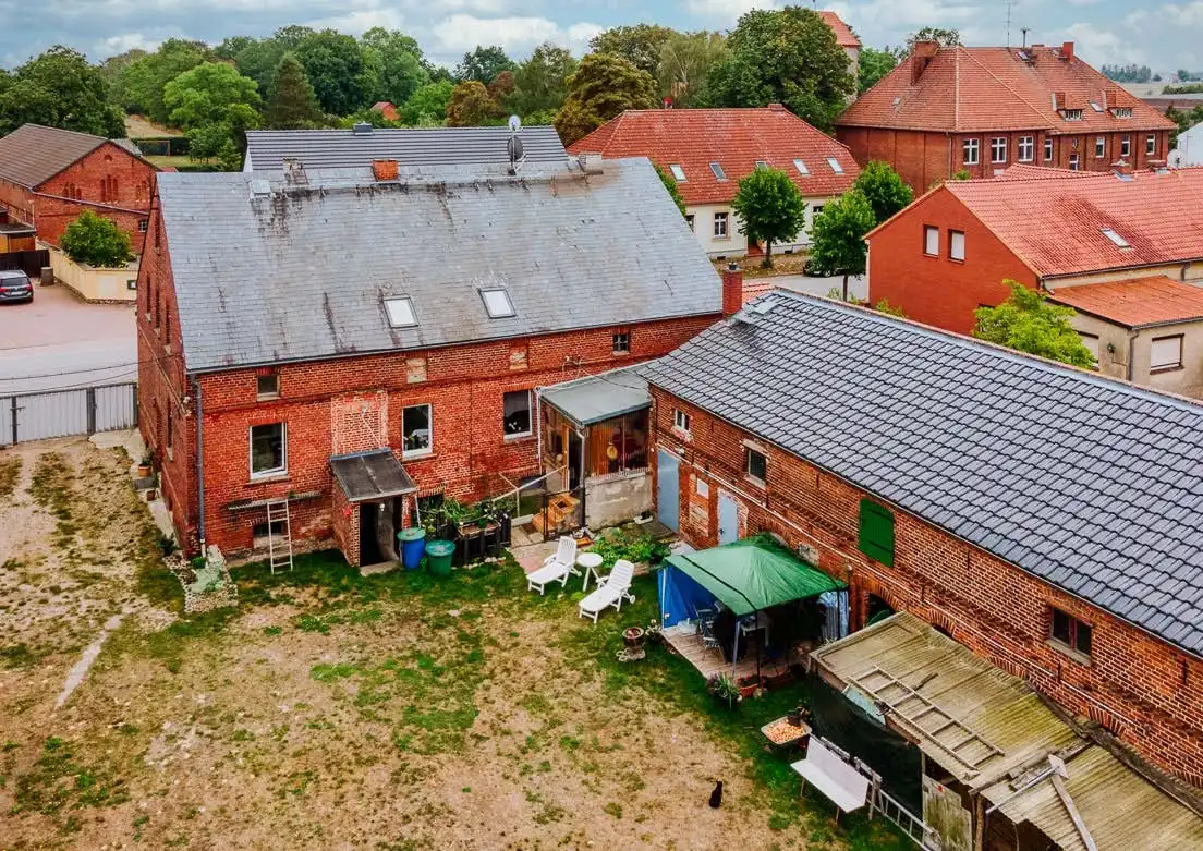Hofseite des Dreiseitenhofs mit Wohnhaus und Scheunen in Breddin, Drohnenaufnahme