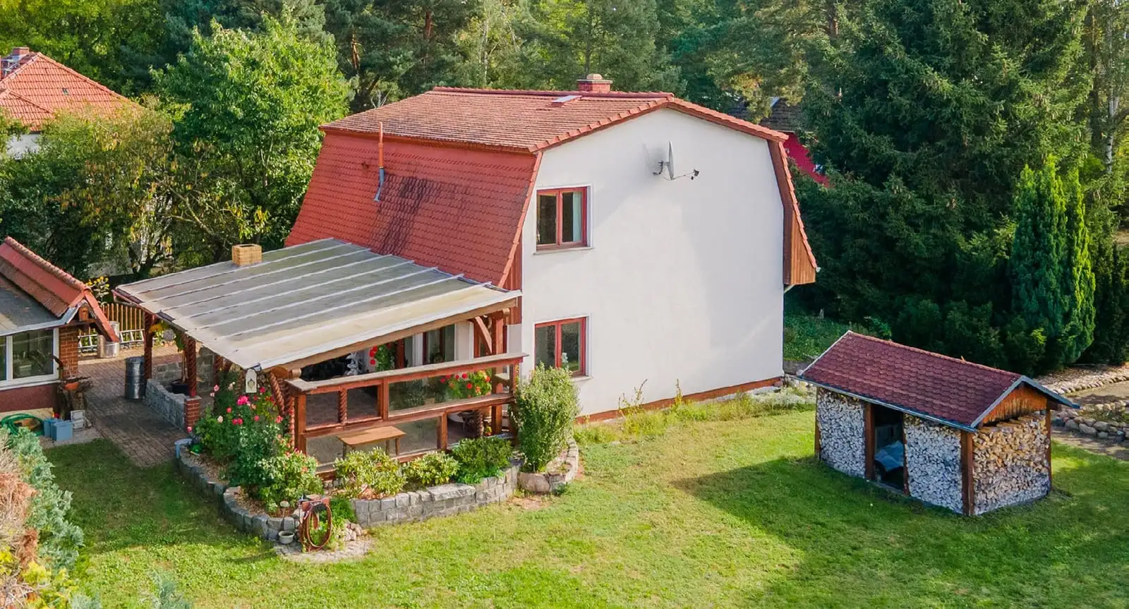 Einfamilienhaus mit Mansarddach, überdachter Terrasse und Holzschuppen in Berlin-Müggelheim, Foto aus dem Exposé