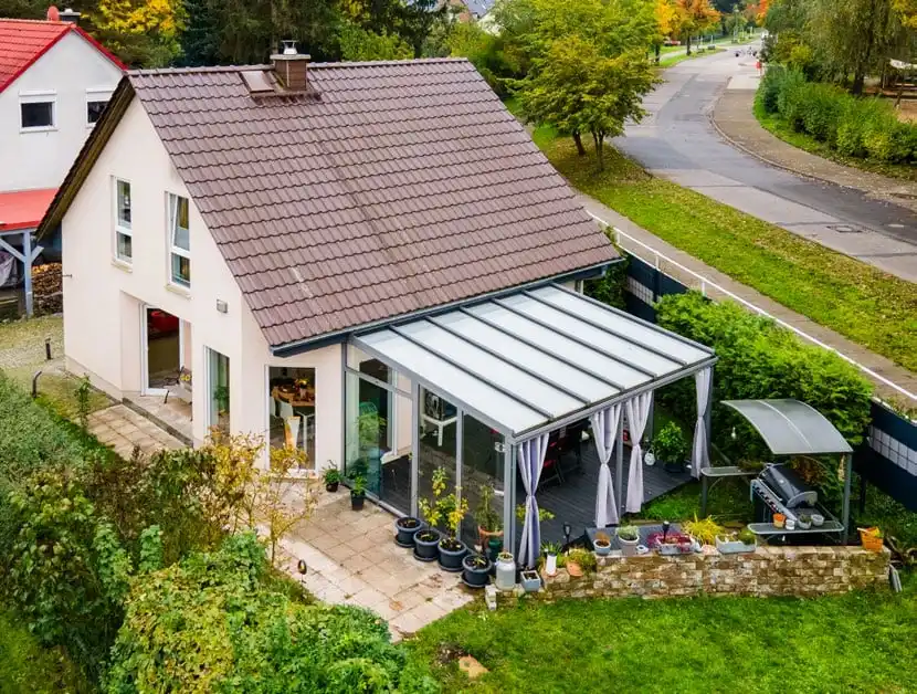 Einfamilienhaus mit braunem Ziegeldach und Wintergarten von oben in Ahrensfelde