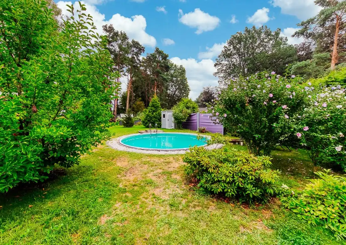 Garten mit Rasen, Büschen und Pool in Hangelsberg bei Grünheide