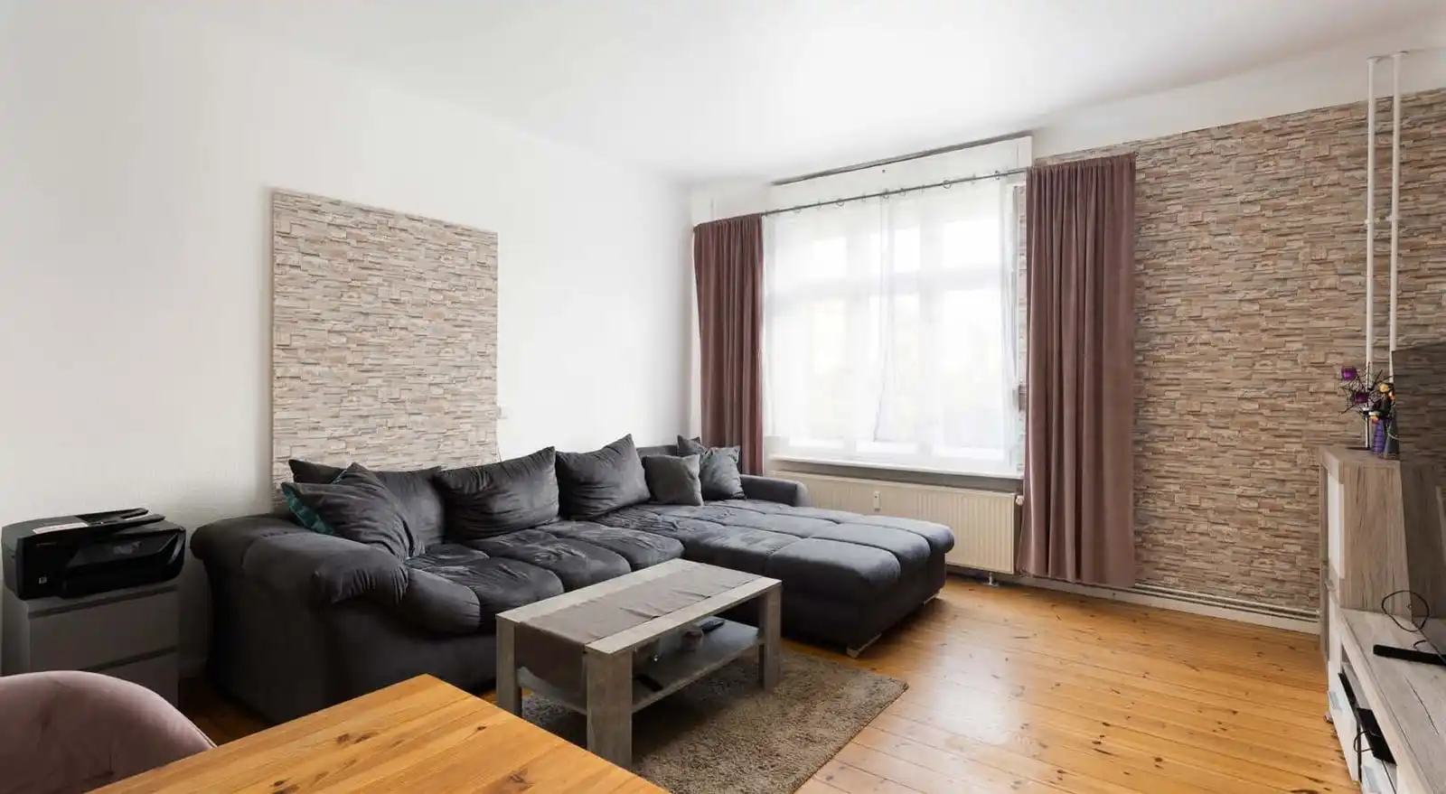 Wohnzimmer mit Steinwand und Fenster in der Eigentumswohnung in Hennigsdorf