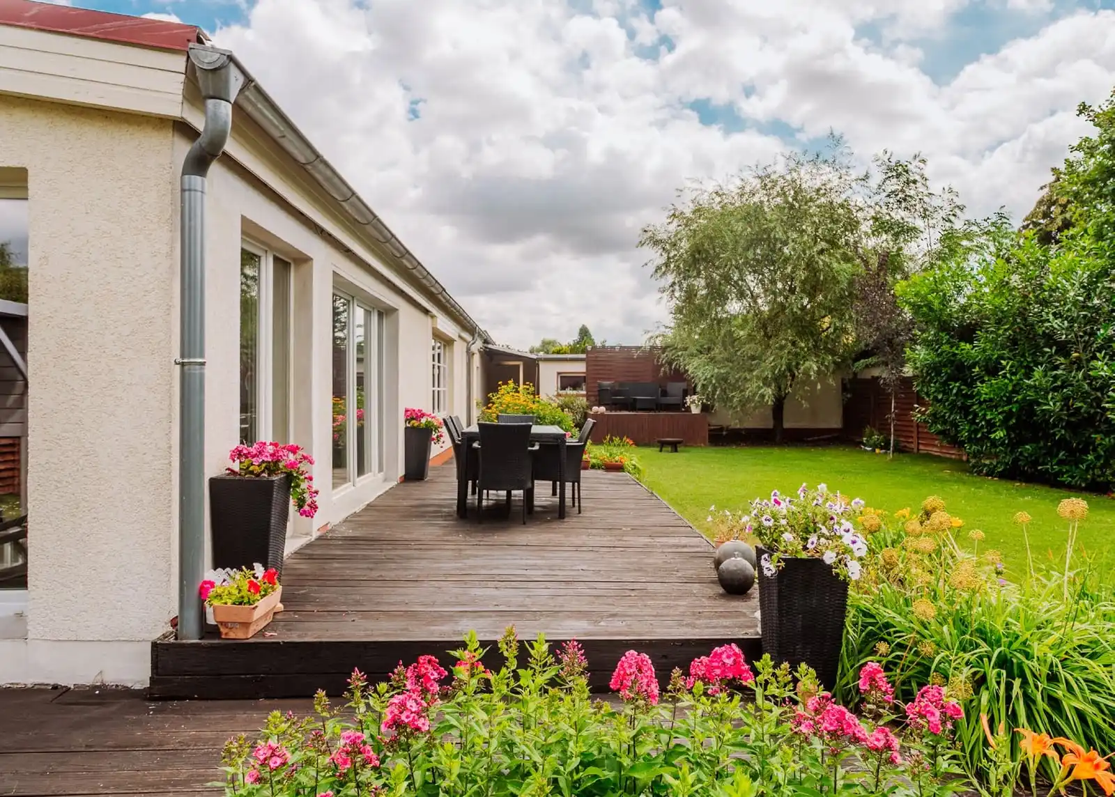 Holzterrasse mit Sitzgruppe und Blumen an der Doppelhaushälfte in Berlin-Mahlsdorf