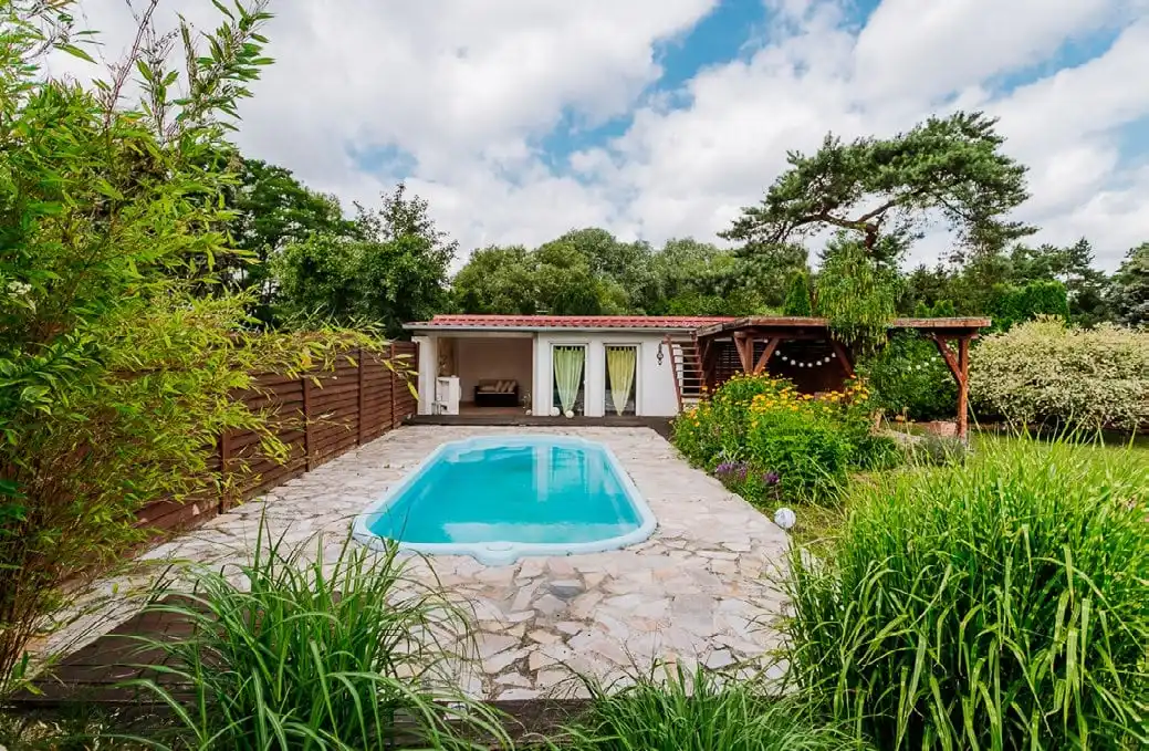 Pool mit Natursteinumrandung und Gartenhaus in Berlin-Mahlsdorf
