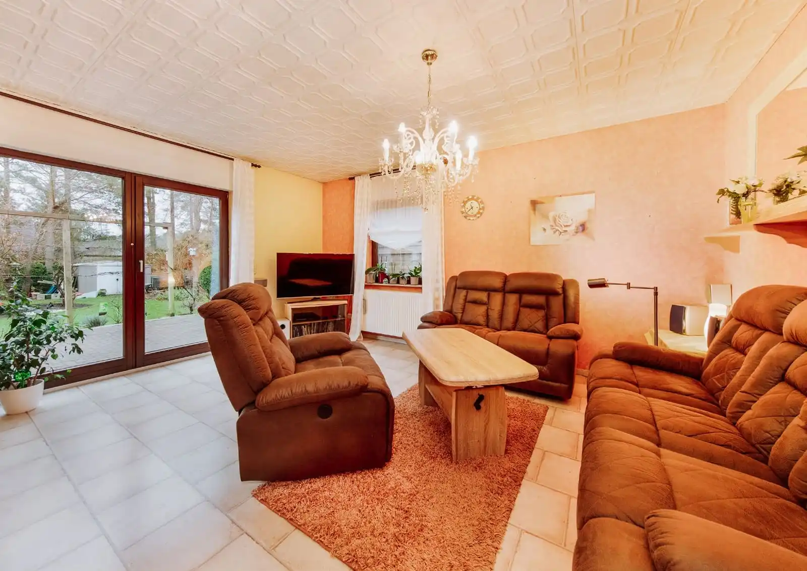 Wohnzimmer mit Ledersofas und Fenstertür zum Garten im Einfamilienhaus in Borkheide