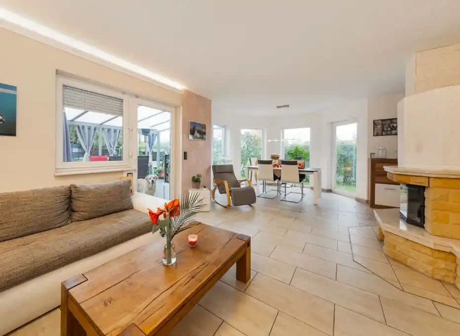 Wohnbereich mit Fliesenboden, Kamin und Sofa im Einfamilienhaus in Ahrensfelde
