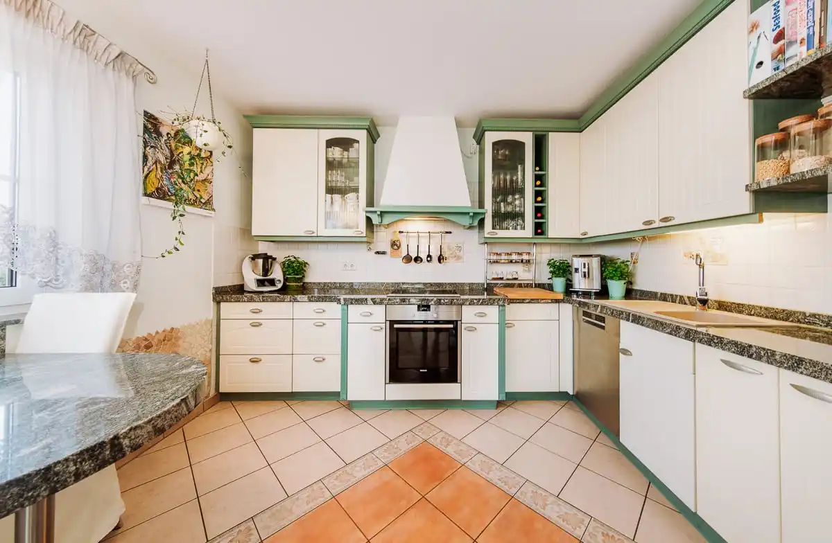Küche mit hellen Schränken und Granitplatte im Einfamilienhaus in Brieselang
