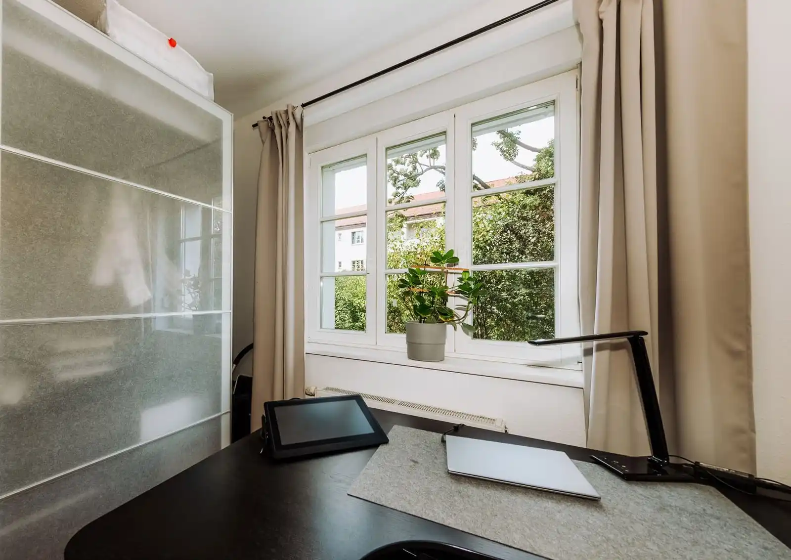 Arbeitsplatz am Fenster mit Vorhängen in der Eigentumswohnung in Berlin-Adlershof
