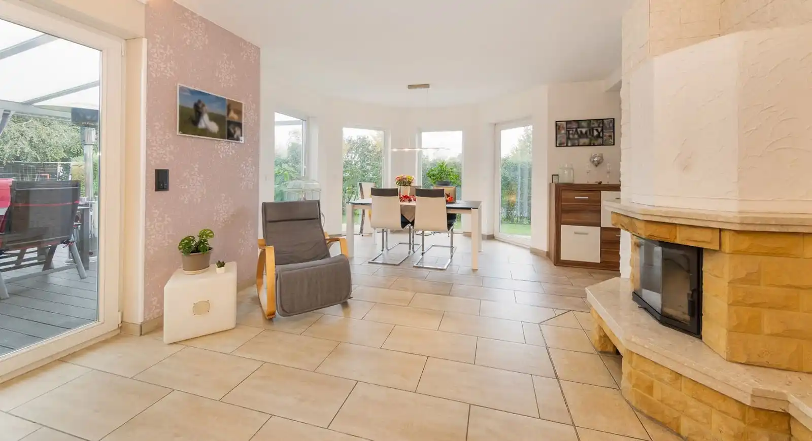 Wohn- und Essbereich mit Kamin und Fenstertür zur Terrasse im Einfamilienhaus in Ahrensfelde