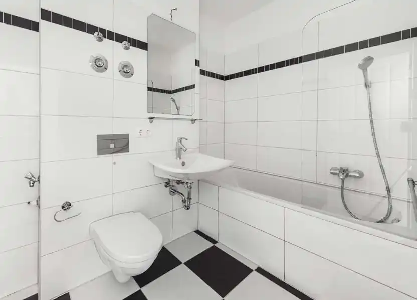 Badezimmer mit Badewanne und schwarz-weißen Fliesen in der Eigentumswohnung in Berlin-Karlshorst