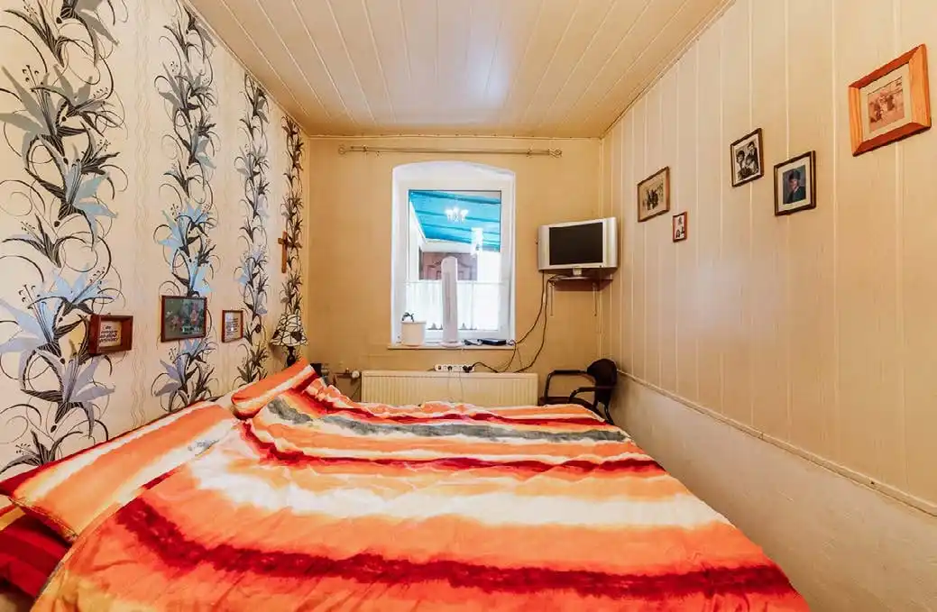 Schlafzimmer mit Holzverkleidung im Wohnhaus des Dreiseitenhofs in Breddin