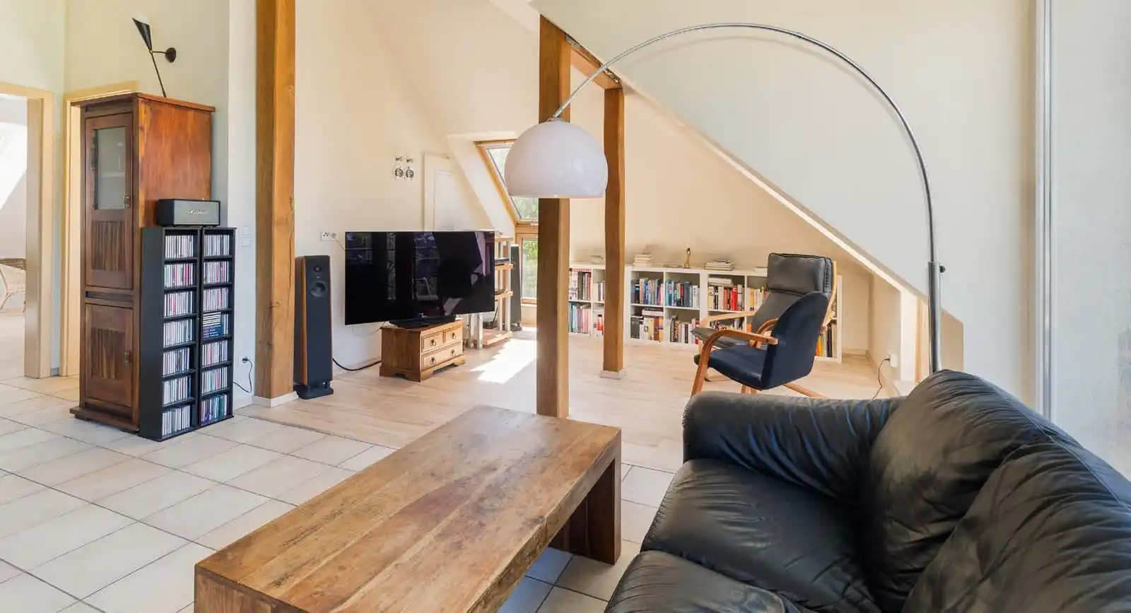 Wohnzimmer mit Ledersofa und Holzbalken in der Eigentumswohnung in Wandlitz