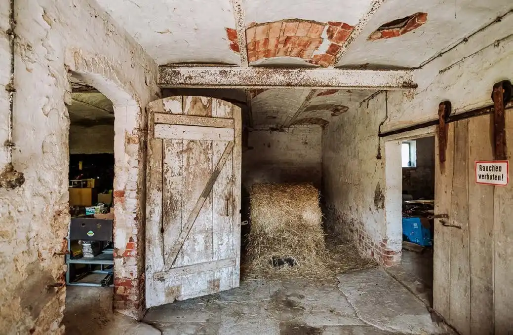 Stall mit Holztüren und Backsteinmauern im Dreiseitenhof in Breddin
