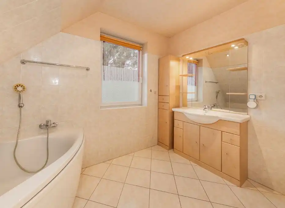 Badezimmer mit Eckbadewanne und Waschtisch im Einfamilienhaus in Ahrensfelde