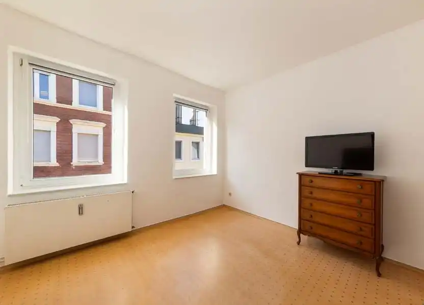 Zimmer mit Kommode und Fernseher im Mehrfamilienhaus in Luckenwalde