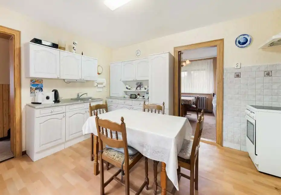 Küche mit weißen Schränken und Esstisch im Einfamilienhaus in Neuhof bei Angermünde