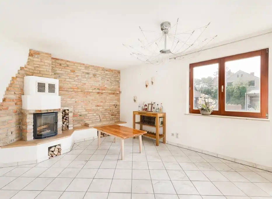 Wohnzimmer mit Kachelofen und Backsteinwand im Einfamilienhaus in Berlin-Müggelheim