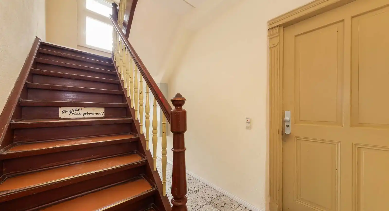 Treppenhaus mit Holzstufen und Wohnungstür im Mehrfamilienhaus in Luckenwalde