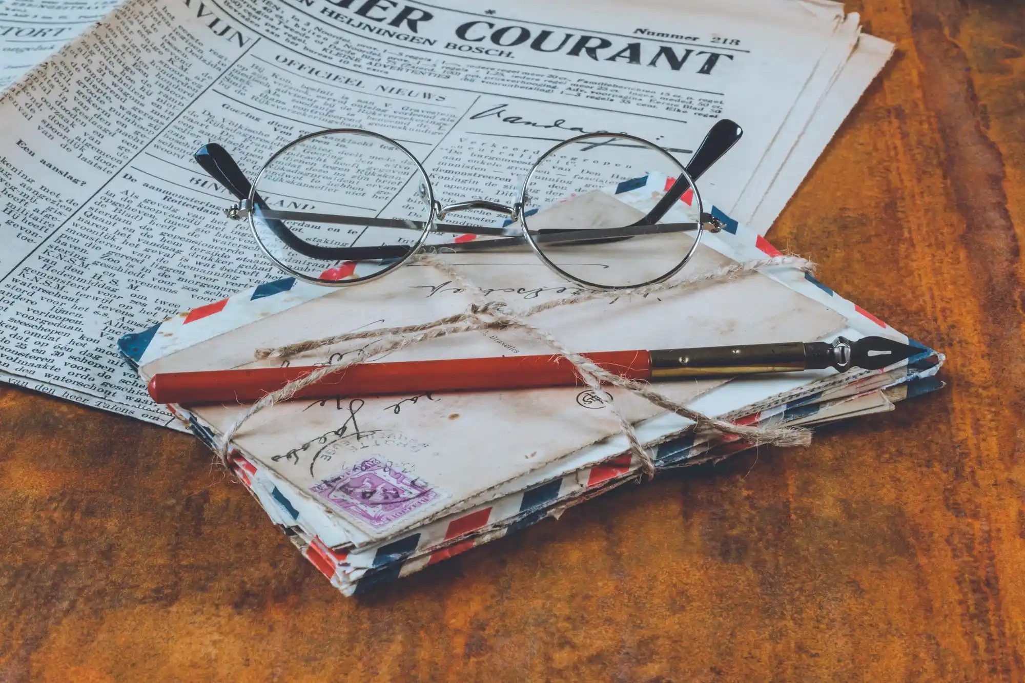 Alte Briefe, Stift und Brille auf einem Holztisch