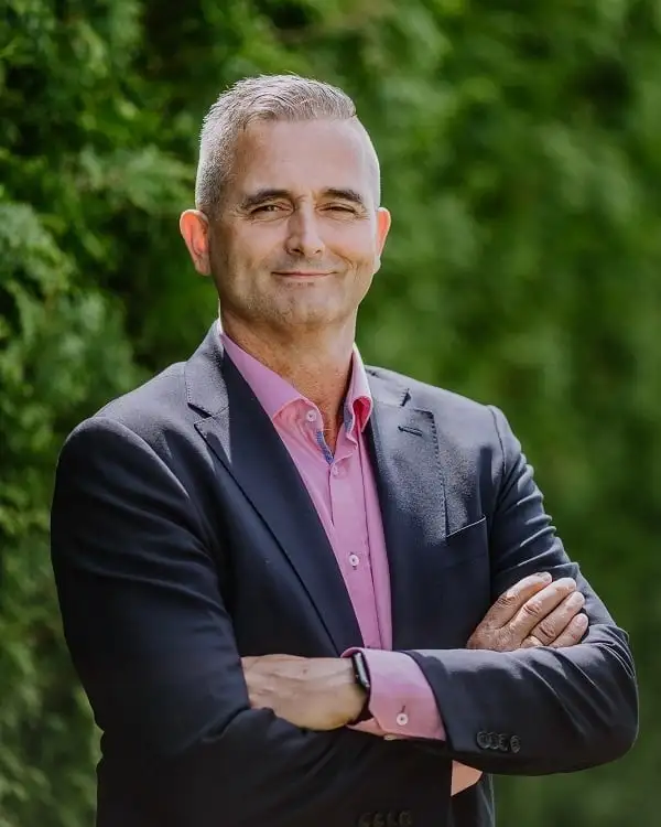 Ralf Lindenau, Porträt vor einer grünen Hecke