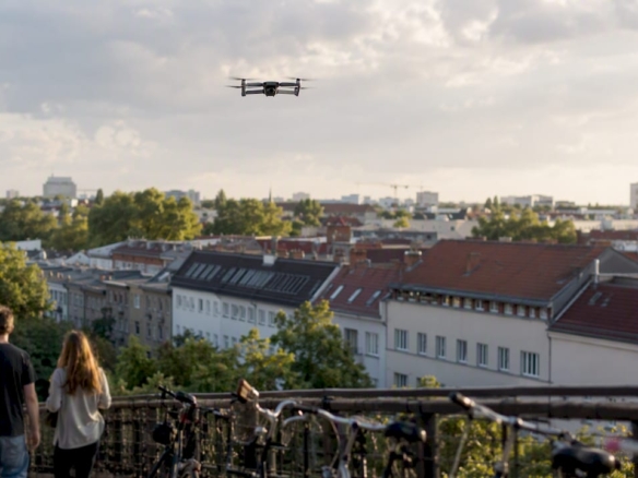 Eine Drohne schwebt über den Wohnhäusern in Berlin.