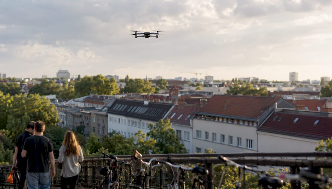 Eine Drohne schwebt über den Wohnhäusern in Berlin.